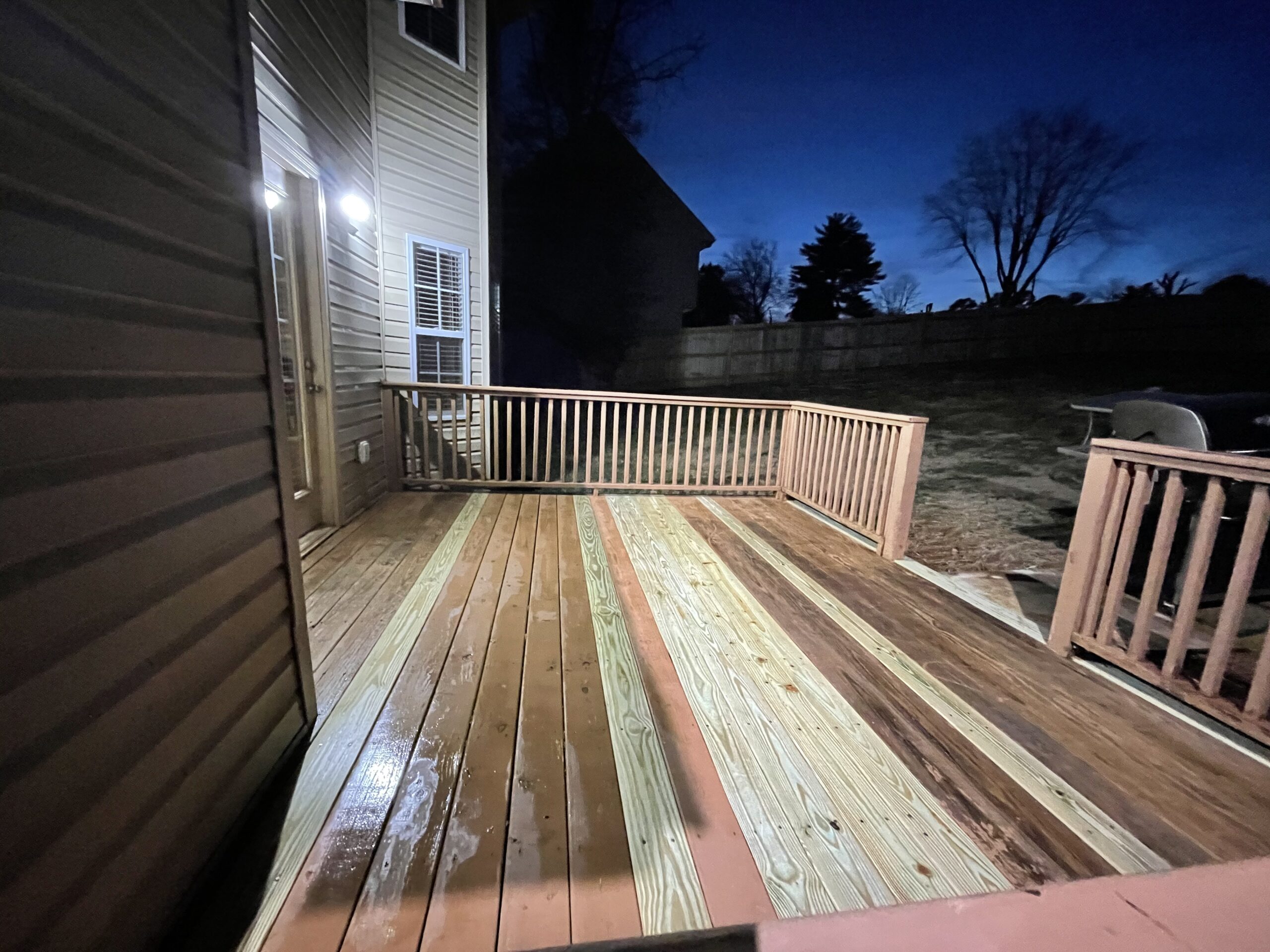 A newly cleaned and stained deck with multiple wood planks treated.