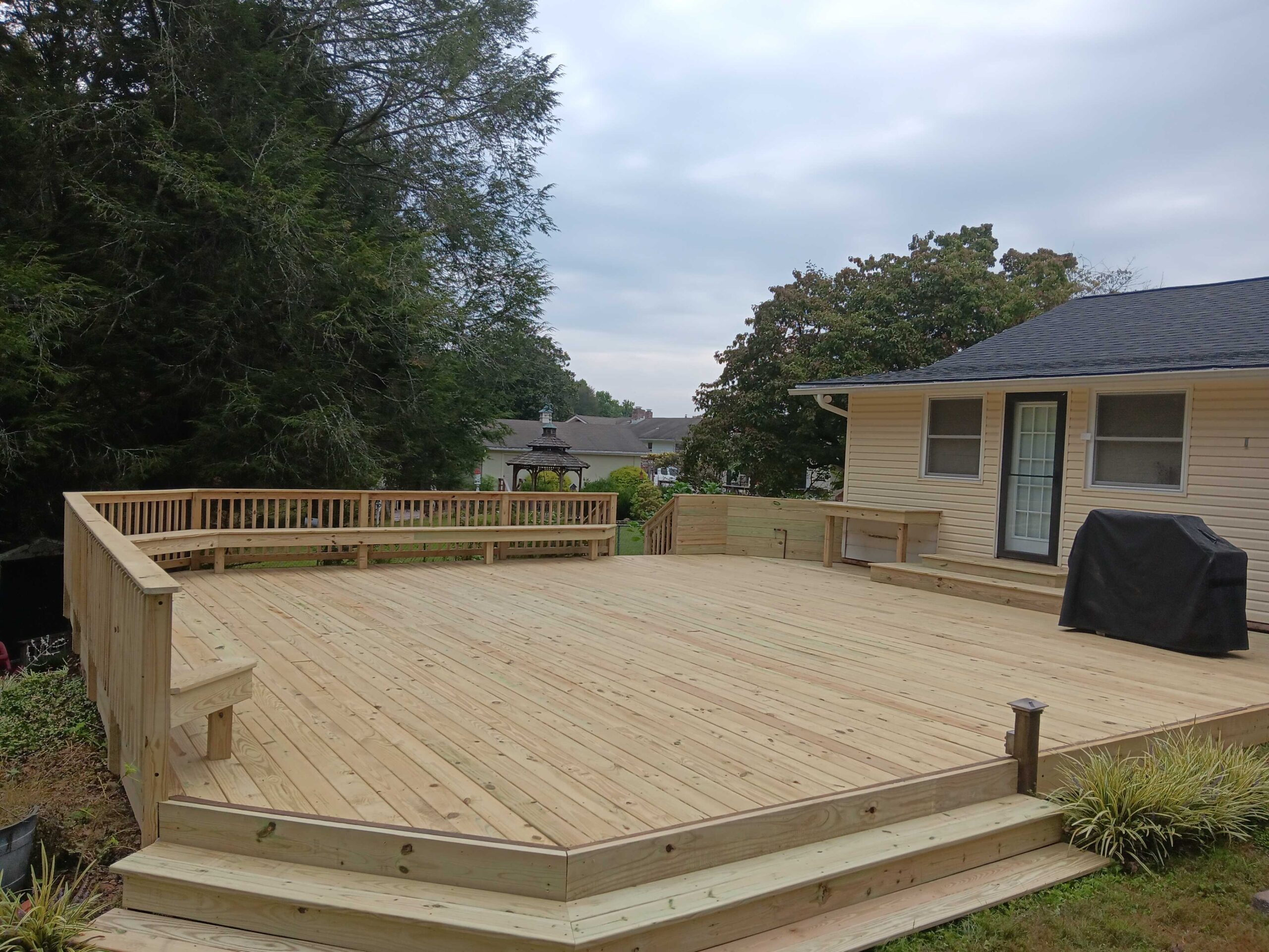 Building a large deck with newly laid planks and framing work underway.