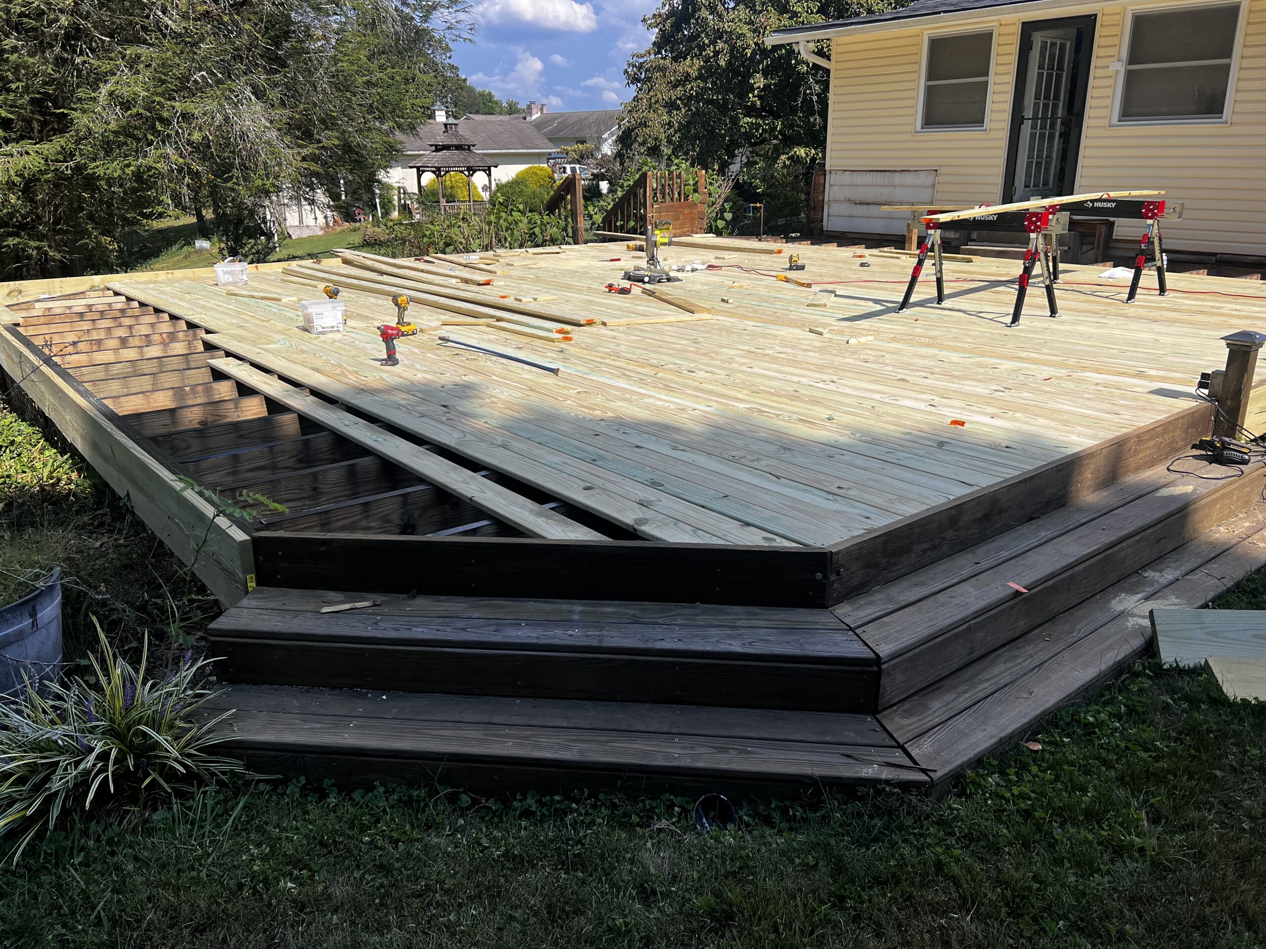 Ongoing deck rebuild project with partially installed wooden planks.