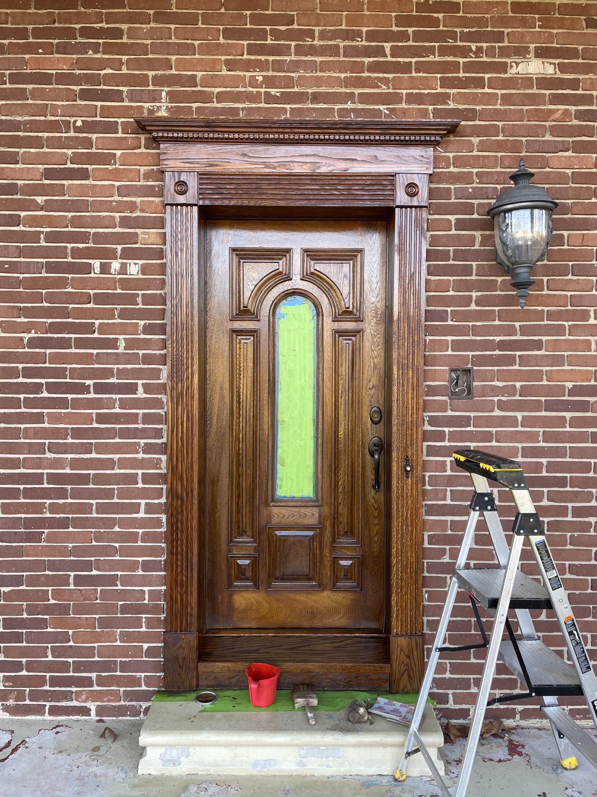 Refinishing a wooden front door with fresh stain and sealant.