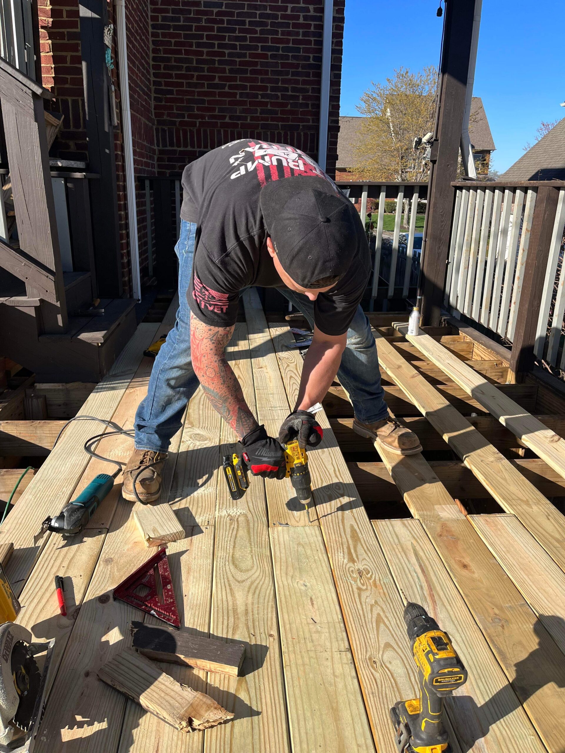 Worker reinforcing the deck's wooden frame for structural support.