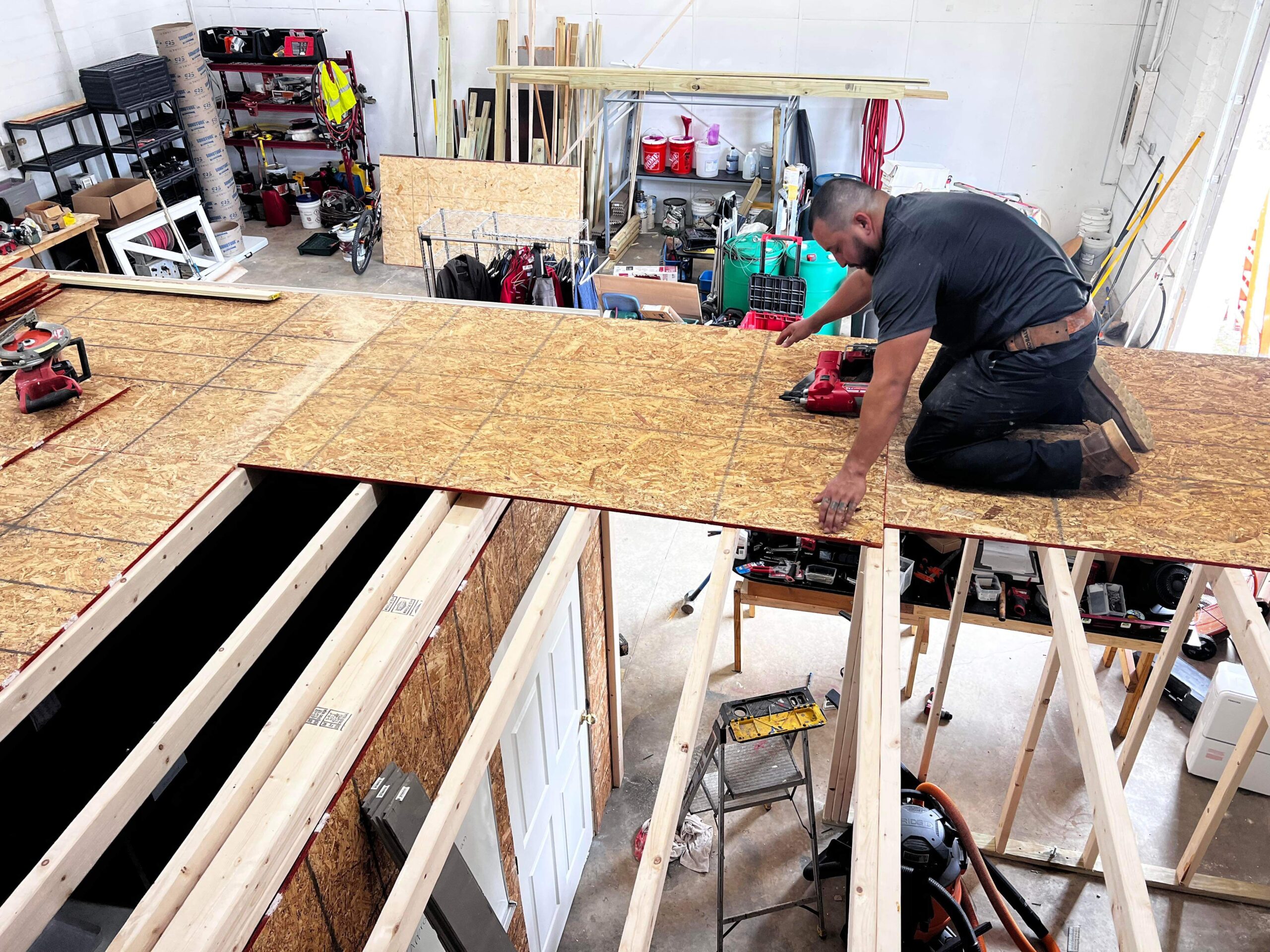 Workers installing new joists during a deck rebuilding project.